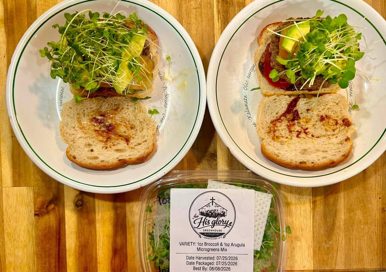 Two open avocado burgers piled with broccoli and arugula microgreens