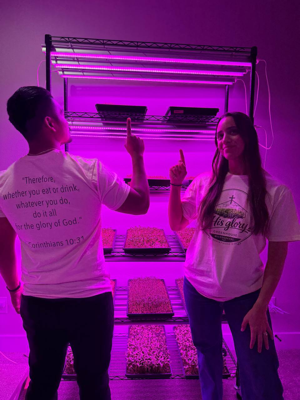 The founders pointing up, one wearing a shirt printed with 1 Corinthians 10:31